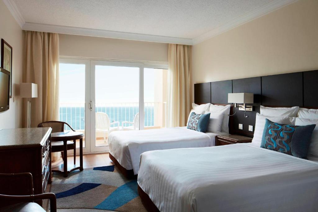 Hurghada Marriott Beach Resort في الغردقة: غرفة فندقية بسريرين ونافذة كبيرة