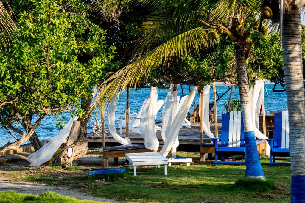 Tintipan Hotel في Tintipan Island: مجموعة من الكراسي والأراجيح على الشاطئ