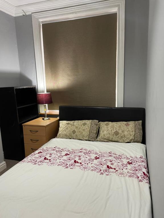 a bedroom with a bed with a floral bedspread at Transformative housing Exeter Road in Nottingham