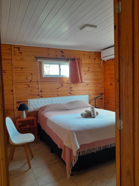 a bedroom with a bed and a chair in a room at Itsasoa in Barra del Chuy