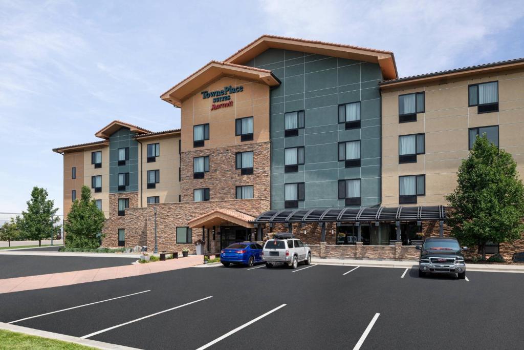 a hotel with cars parked in a parking lot at TownPlaces Suite Denver Airport at Gateway Park in Aurora