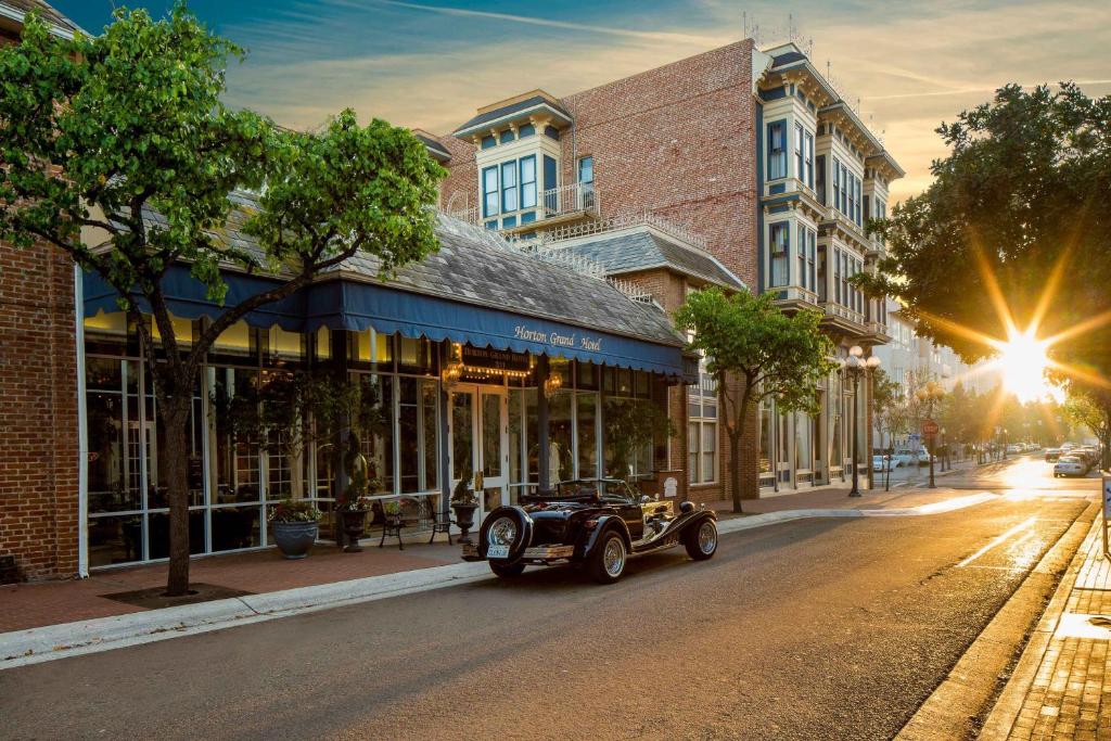 un coche vintage aparcado en una calle frente a un edificio en Horton Grand Hotel en San Diego