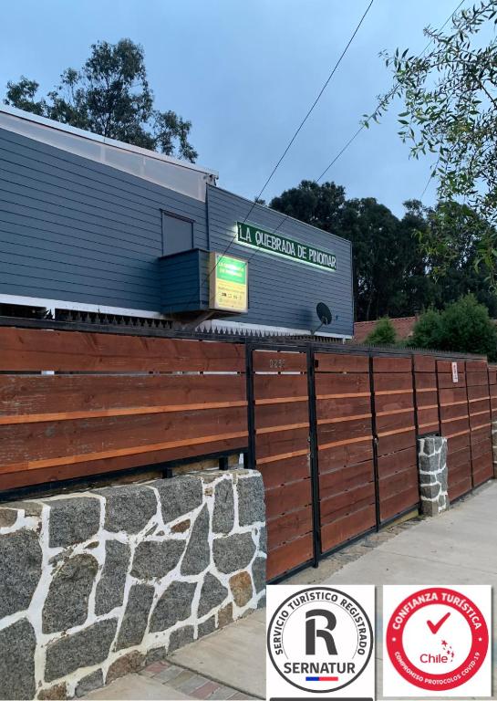 a building with a sign on top of a fence at La Quebrada de Pinomar in El Quisco