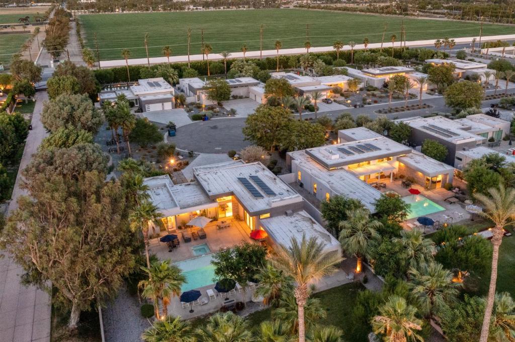 een luchtzicht op een huis met een zwembad en palmbomen bij Polo Villa 1 by AvantStay Features Expansive Pool, Spa & Outdoor Firepit 260-322 5 Bedrooms in La Quinta