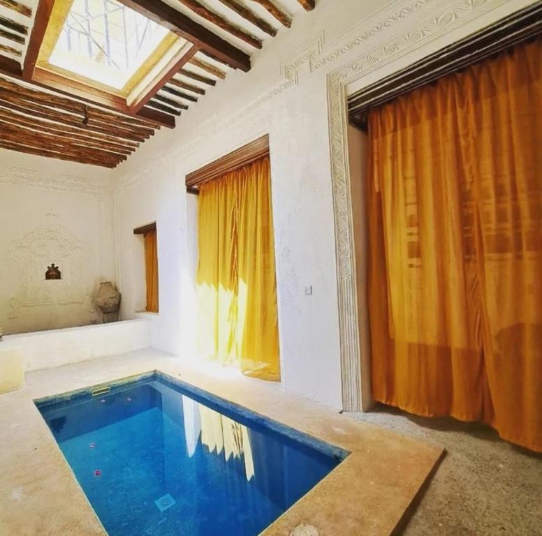 a swimming pool in a room with a window at Makubwa House in Lamu