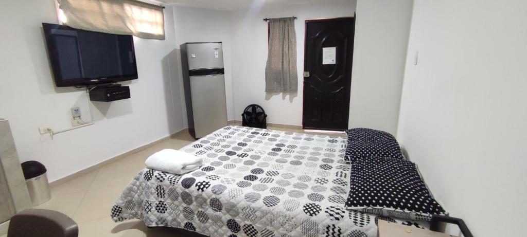 a room with a bed and a flat screen tv at Genial Loft Tipo Smart San Alonso in Bucaramanga