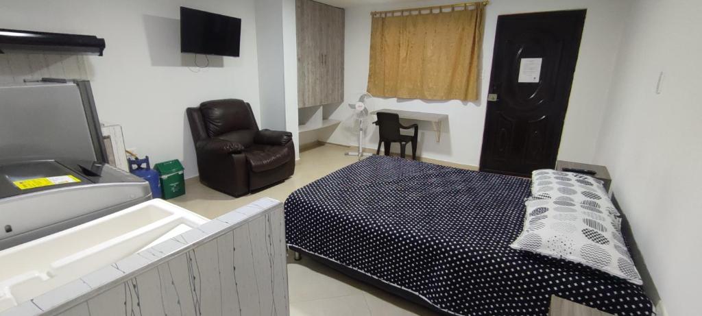 1 dormitorio con 1 cama, 1 silla y TV en Moderno y Confortable San Alonso en Bucaramanga