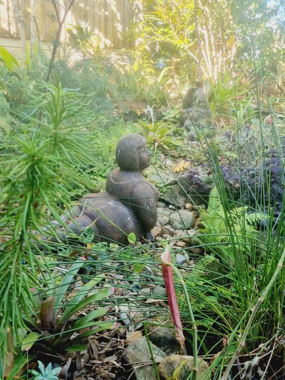 Una statua di una donna seduta in un giardino di Birdsong Retreat - A BnB on Lamb Island 