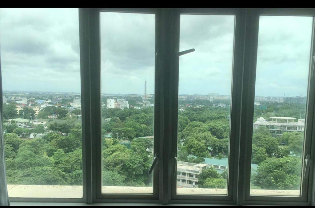 a view of a city from a window at Penthouse Cozy Room + Netflix Near at Venice Mall in Manila