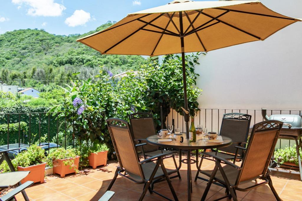 einen Tisch und Stühle mit Sonnenschirm auf einer Terrasse in der Unterkunft Villa Vegent-All equipped Retreat in Antigua Guatemala