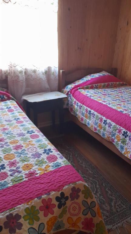 a room with two beds with flowers on them at Hostal kenita in Constitución
