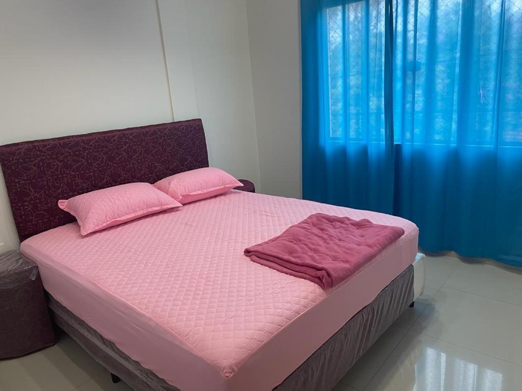 1 dormitorio con 1 cama con sábanas rosas y cortinas azules en Barrio Mburukuja, Calle República de Chile en Ciudad del Este