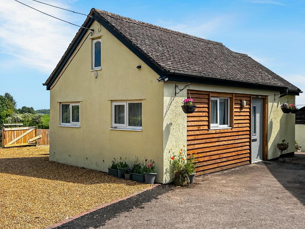 a small house with flowers in front of it at The Lodge in Pauntley