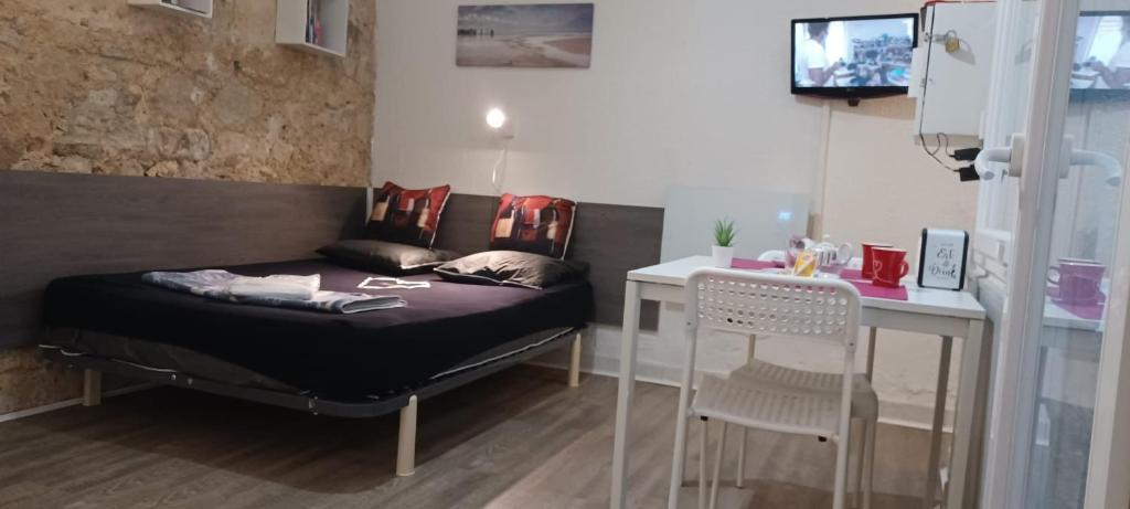 - une chambre avec un lit, un bureau, une table et des chaises dans l'établissement Studio Hypercentre Tourny, à Bordeaux