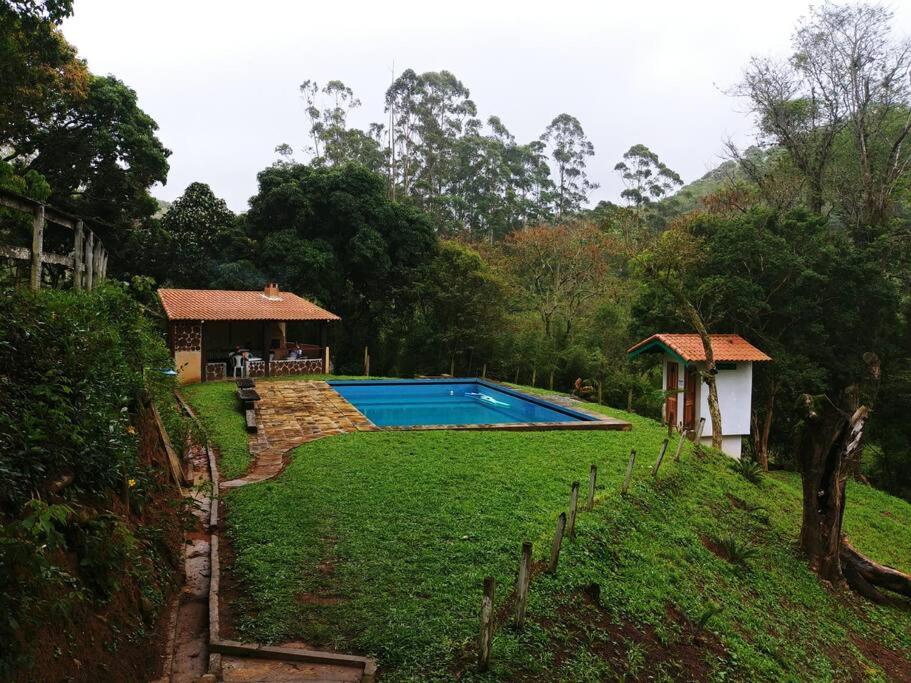 - une piscine dans une cour à côté d'une maison dans l'établissement Casa de Campo: Sítio Santa Helena-Mendes RJ, à Mendes