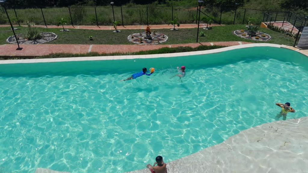 a group of people playing in a swimming pool at hermosa casa en curití in Curití