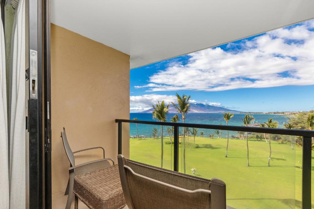 a balcony with a view of a golf course at Kihei Surfside 613 - MCH in Kihei