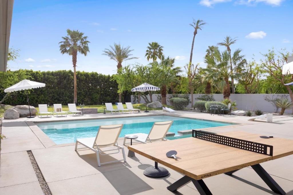 basen z drewnianym stołem i krzesłami obok niego w obiekcie Polo Villa 8 by AvantStay Kitchen, Pool & Spa 260-326 6 Bedrooms w mieście La Quinta