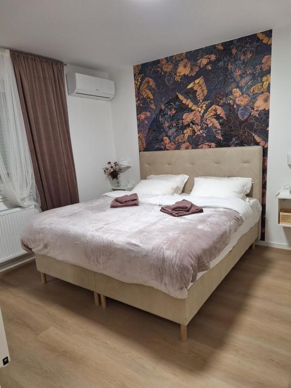 札格雷布的住宿－DOLLY APARTMENT，卧室配有一张大床,墙上挂有绘画作品