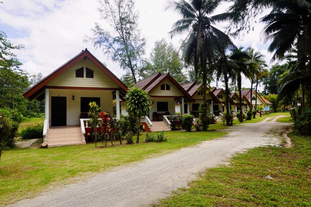 Une rangée de maisons sur un chemin de terre dans l'établissement Smilebeach Resort Khaolak, à Khao Lak