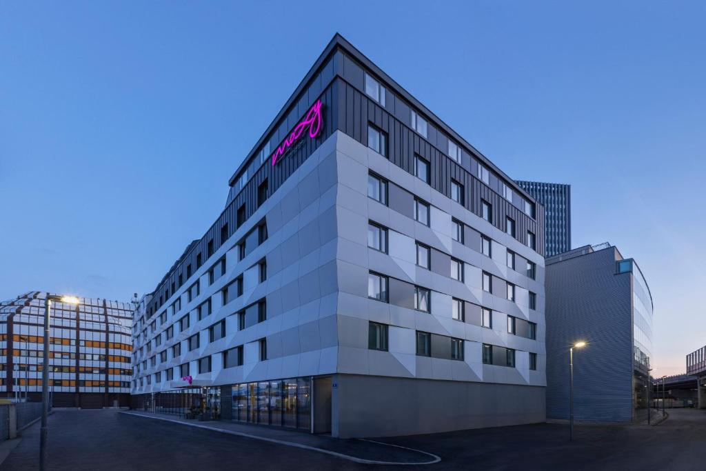 ein weißes Gebäude mit einem rosa Schild drauf in der Unterkunft Moxy Vienna City East in Wien