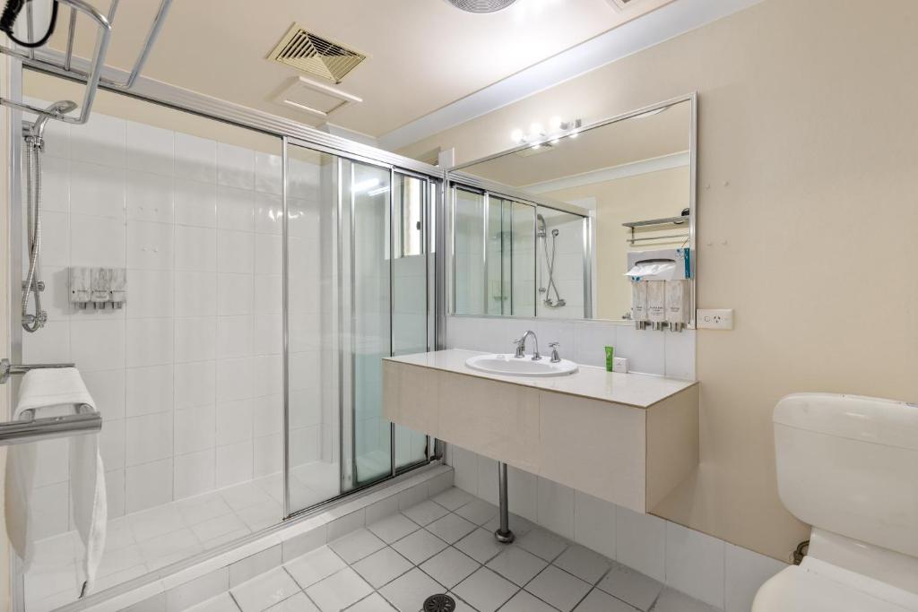 a bathroom with a sink and a shower at Sanctuary Resort Motor Inn in Coffs Harbour