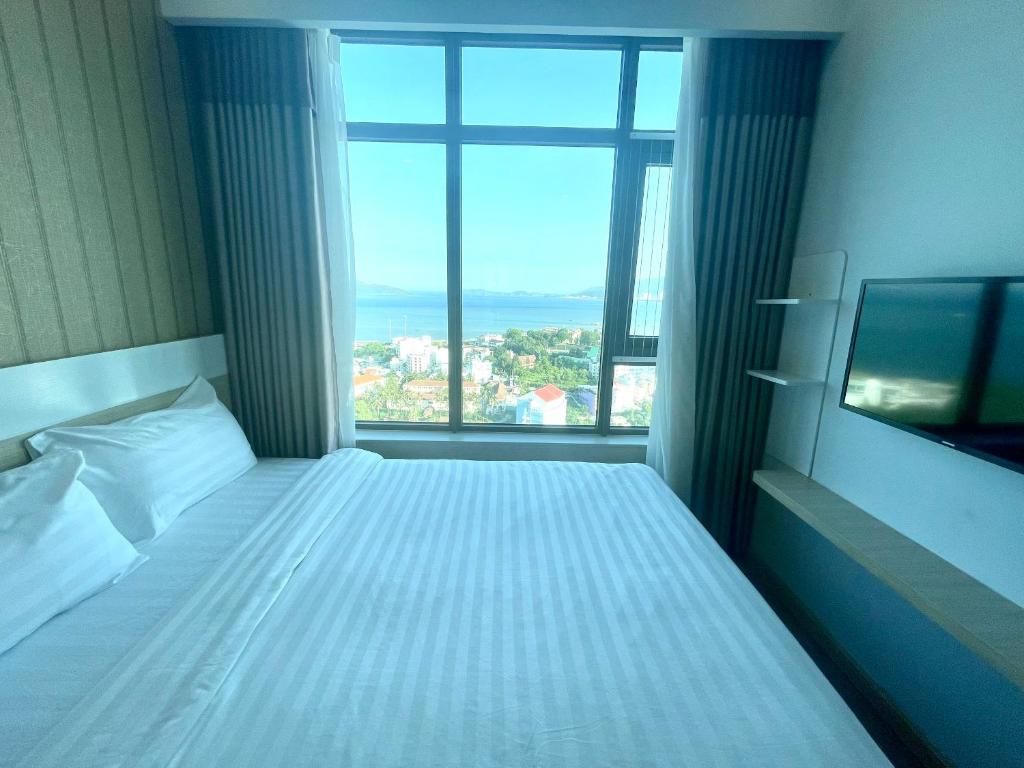 a bedroom with a bed with a large window at Mường Thanh Oceanus Apartment in Nha Trang