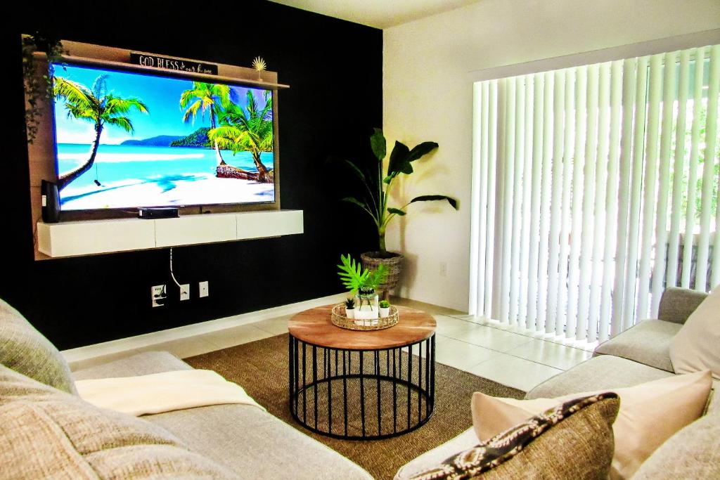 sala de estar con TV de pantalla plana en la pared en Cozy 3 Bed Home Gated Great Location for Disney, en Loughman