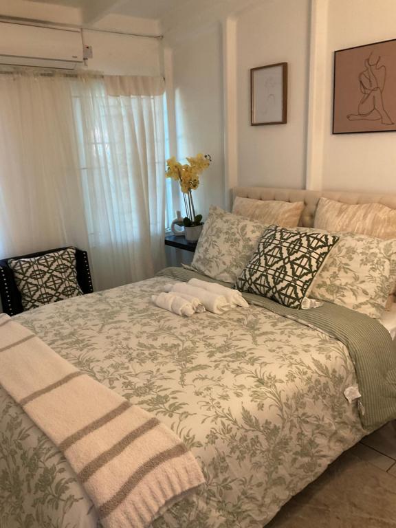 a bed in a bedroom with a blanket and pillows at Travelers Oasis in Portmore