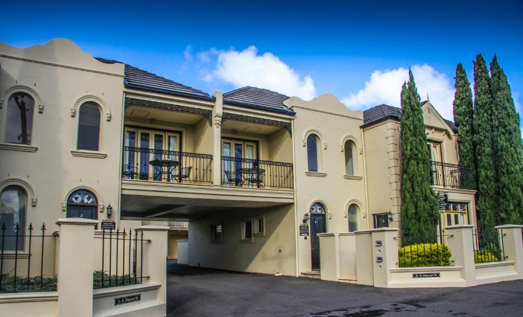a large house with a balcony and trees at Banyan Place in Warrnambool