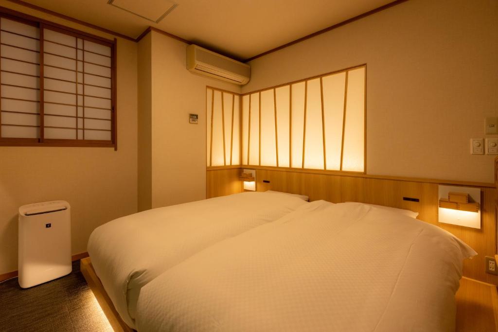 Postel nebo postele na pokoji v ubytování Sake Hotel Tamakiya