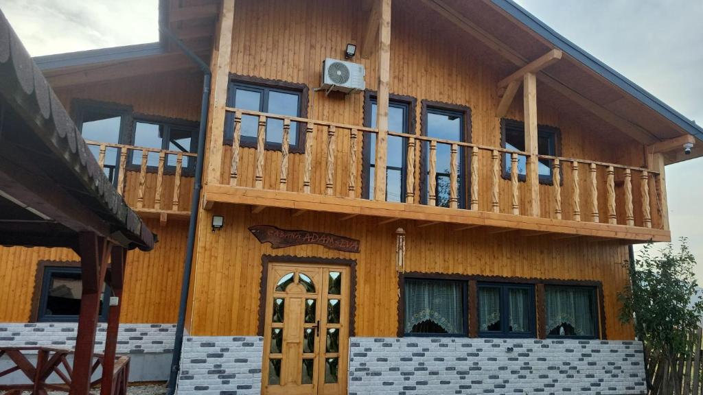 a large wooden house with a balcony on it at CABANA ADAM SI EVA in Gura Râului
