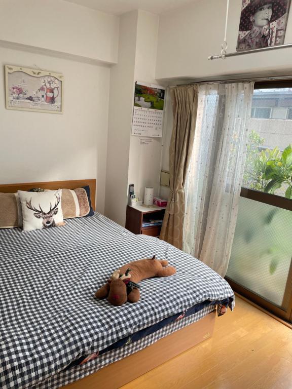 Un dormitorio con una cama con dos ositos de peluche. en 桜宿-ダブルベッドの小さなガーデンルーム en Tokio