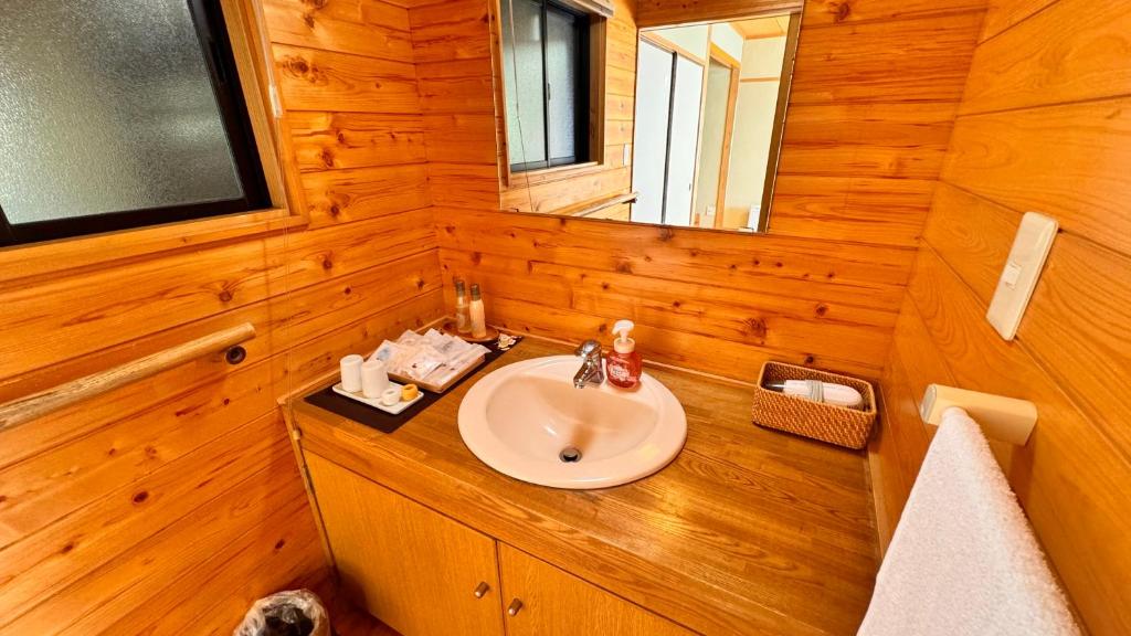 une salle de bains avec un lavabo et un miroir dans l'établissement Ryokan Yamanami, à Yufu