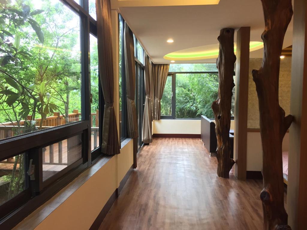einen Flur mit großen Fenstern und Holzböden in der Unterkunft Nantou Xitou Riverside Homestay B&B in Lugu