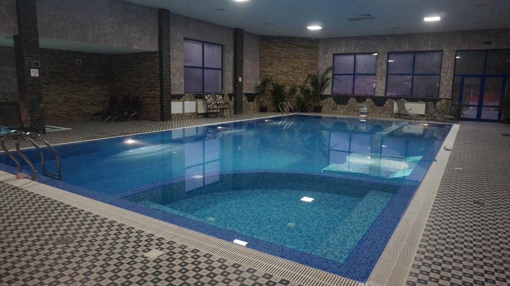 a large blue swimming pool in a building at Хотел Стиляна/Hotel Stilyana in Devin