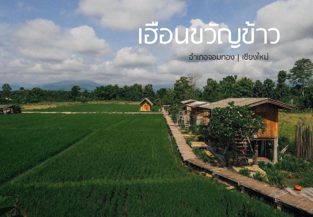 una granja en medio de un campo con una casa en hueankwankao เฮือนขวัญข้าว, 