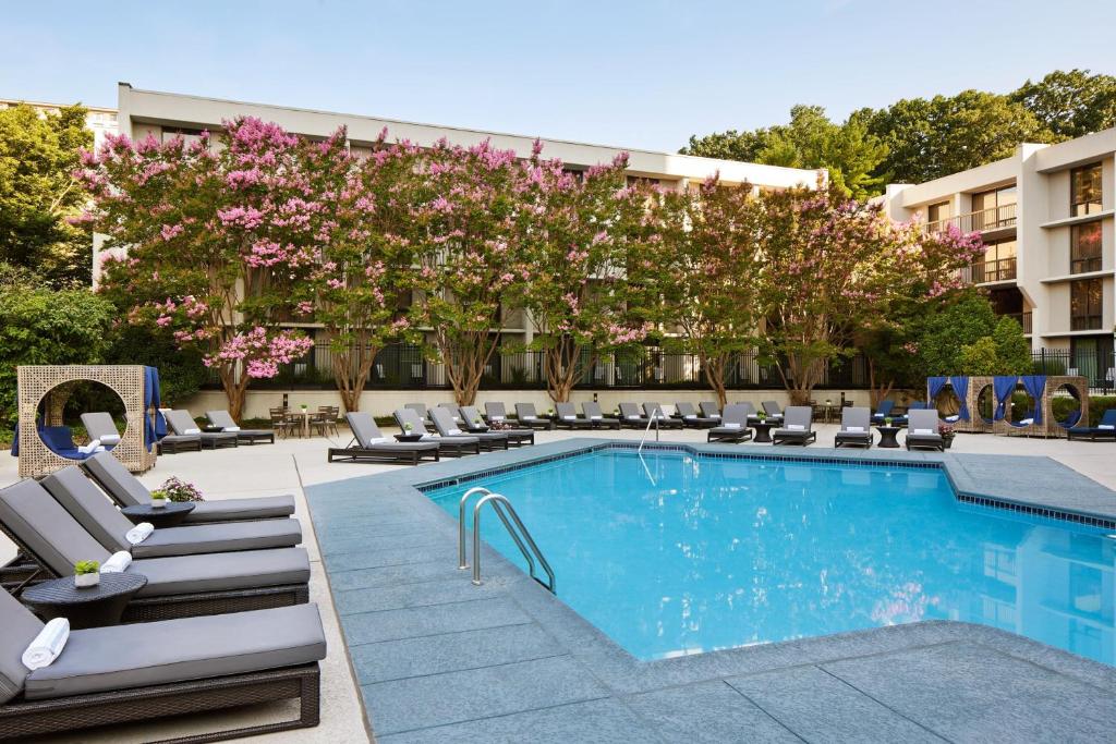 a hotel pool with lounge chairs and pink flowers at Bethesda Marriott in Bethesda