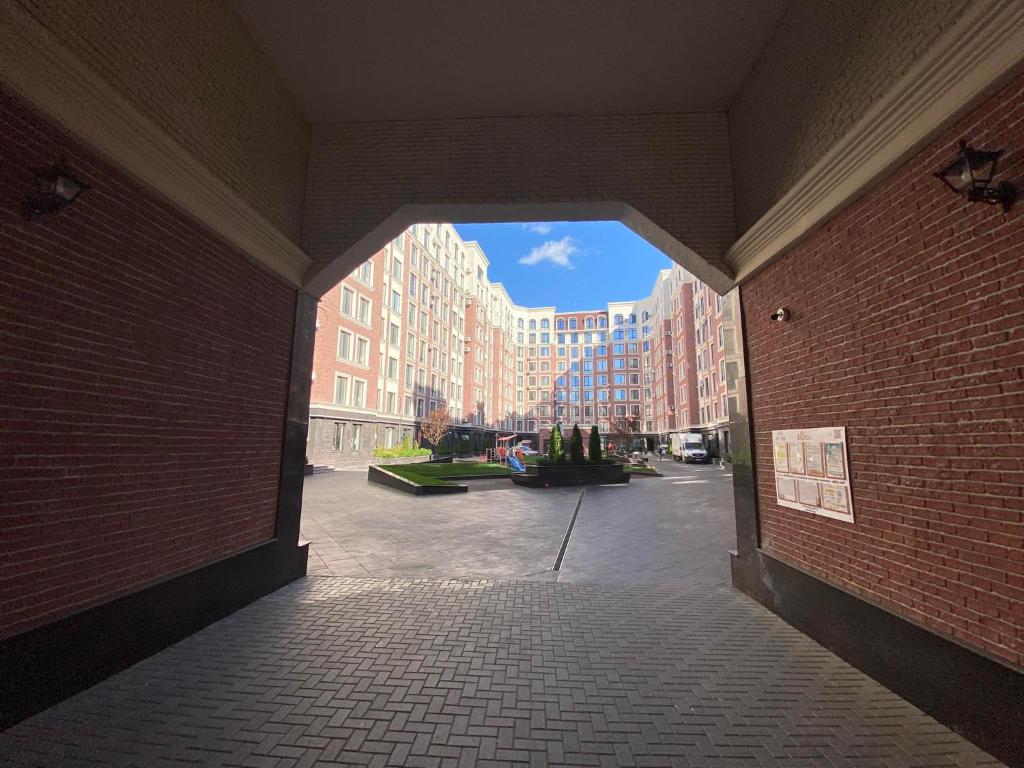 un couloir ouvert avec un mur en briques et des bâtiments dans l'établissement LUX Apartment Av.Iancu floor6, à Chişinău