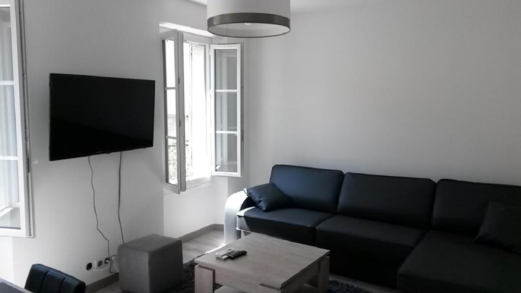 a living room with a couch and a flat screen tv at Safranier Townhouse in Antibes