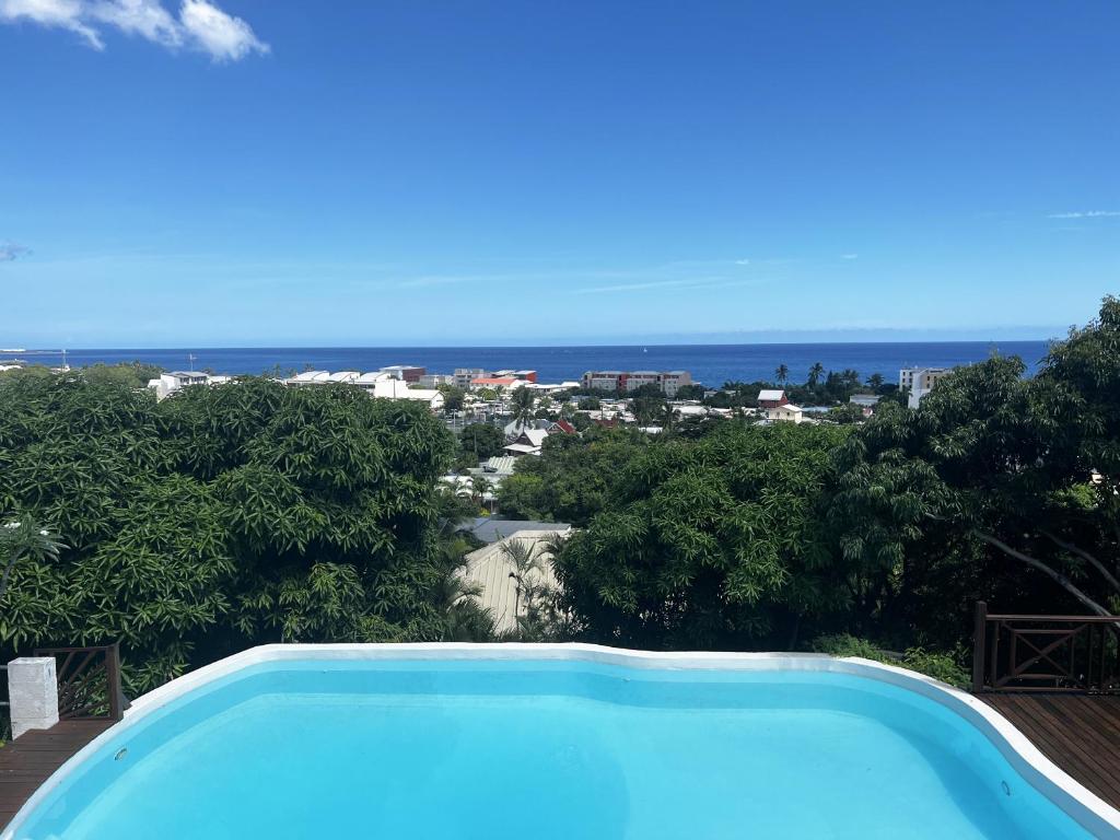 een blauw zwembad met uitzicht op de oceaan bij Villa Oasis in La Possession