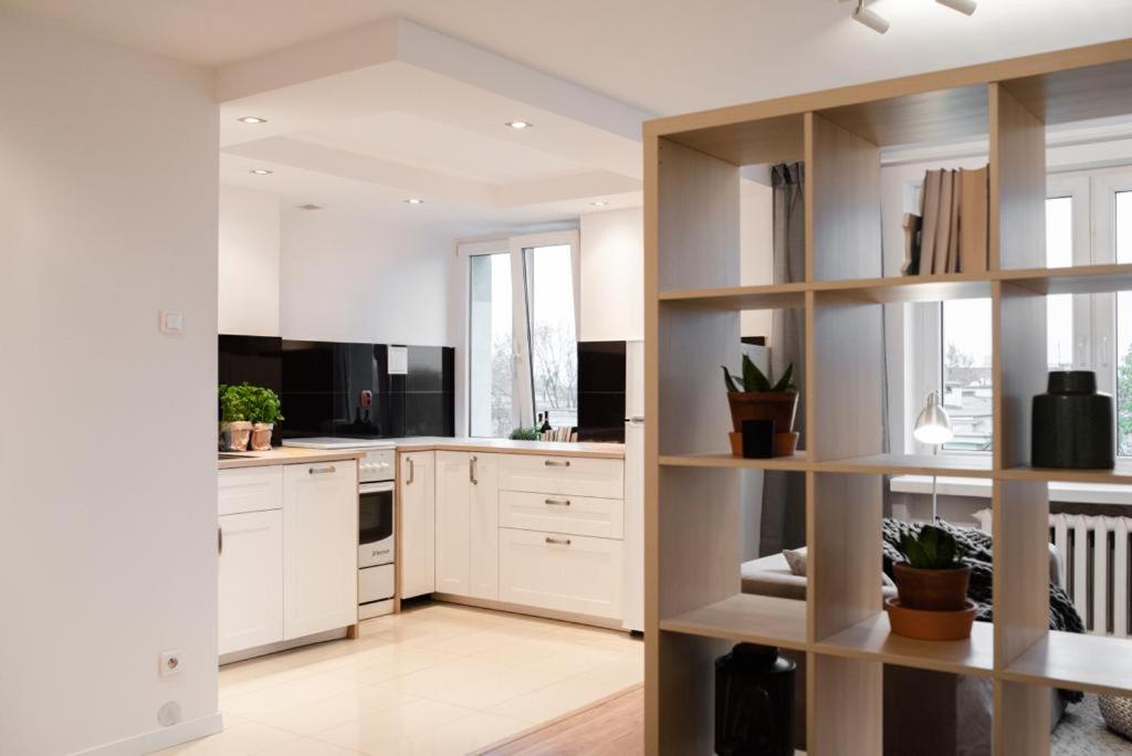 a kitchen with white cabinets and white appliances at Apartament Okrzei in Płock