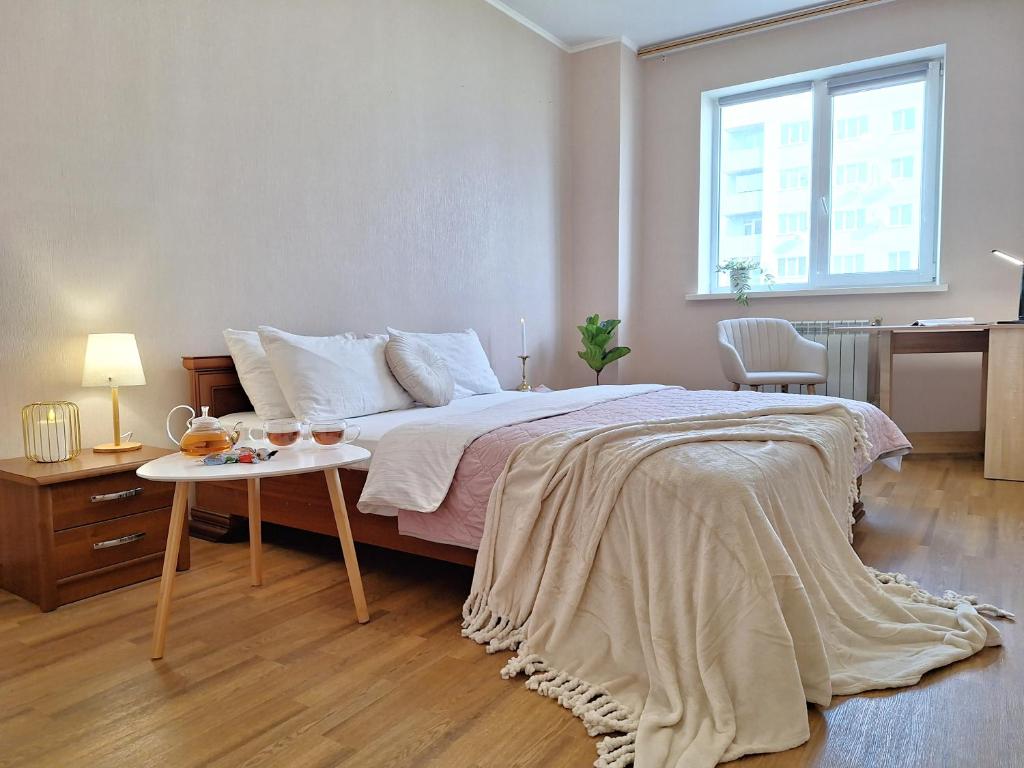a bedroom with a large bed and a table at ЕКО-квартира на Садововому. Мережа Alex Apartments. Цілодобове безконтактне заселення in Shcherbani