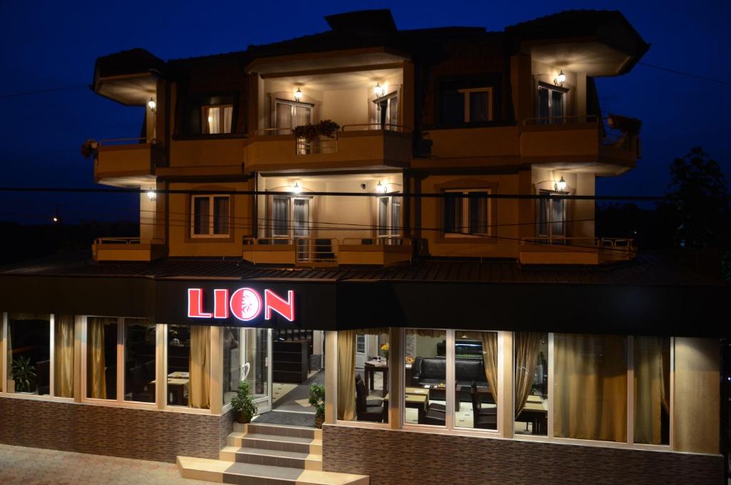 un hotel con un cartello di fronte a un edificio di Garni Hotel Lion a Jagodina