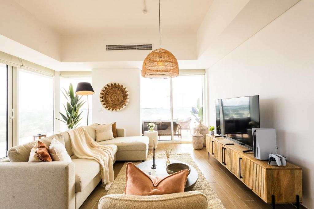 uma sala de estar com um sofá e uma televisão em Voyage 2 Bedroom In Mayan With Ocean Views em Abu Dhabi