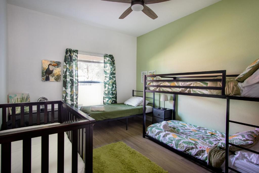 een slaapkamer met 2 stapelbedden en een wieg bij Florida Luxe, Brand new 4 Bed Property with a Private Jacuzzi in Tampa