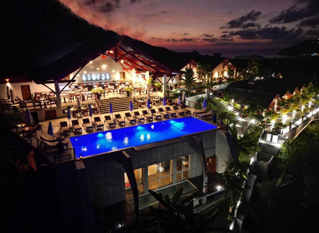 ヌシ・ベーにあるAndriana Resort & Spaの夜の建物内の青いプール付き屋外イベント