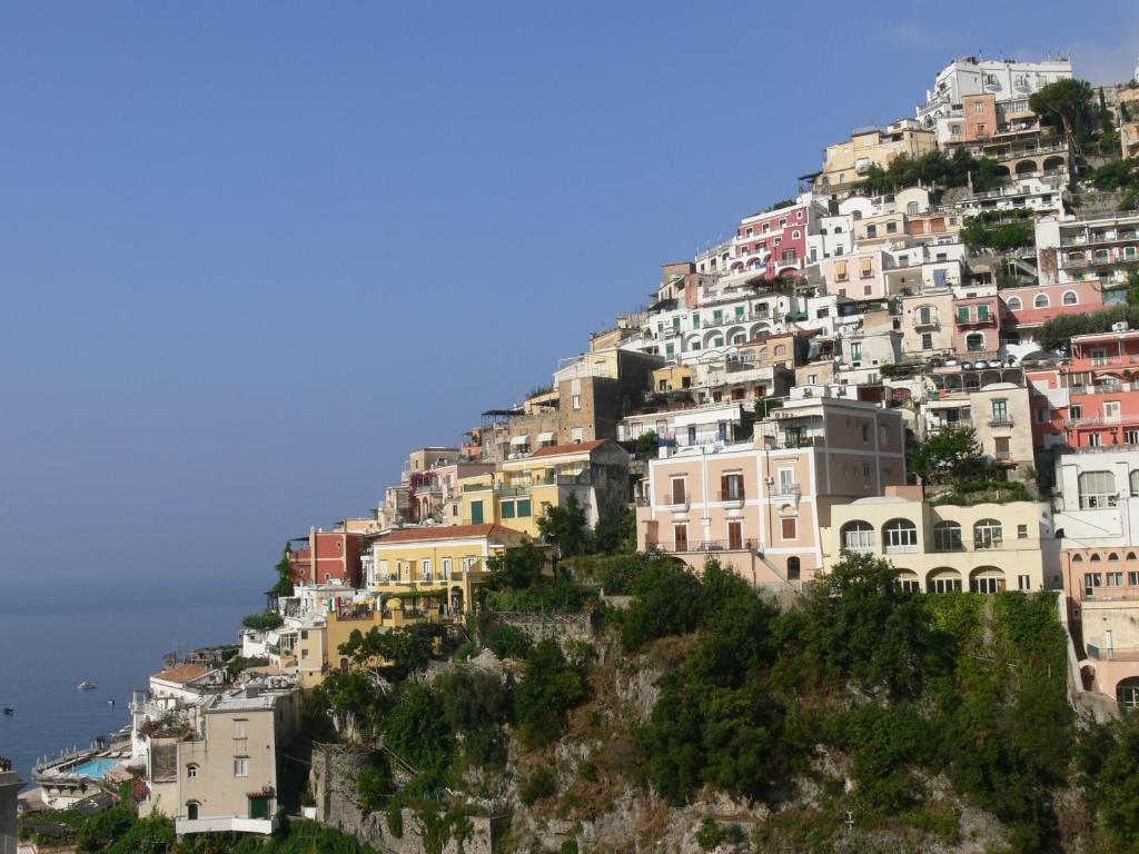 
a cityscape of a city with buildings and mountains at La Tavolozza Residence in Positano
