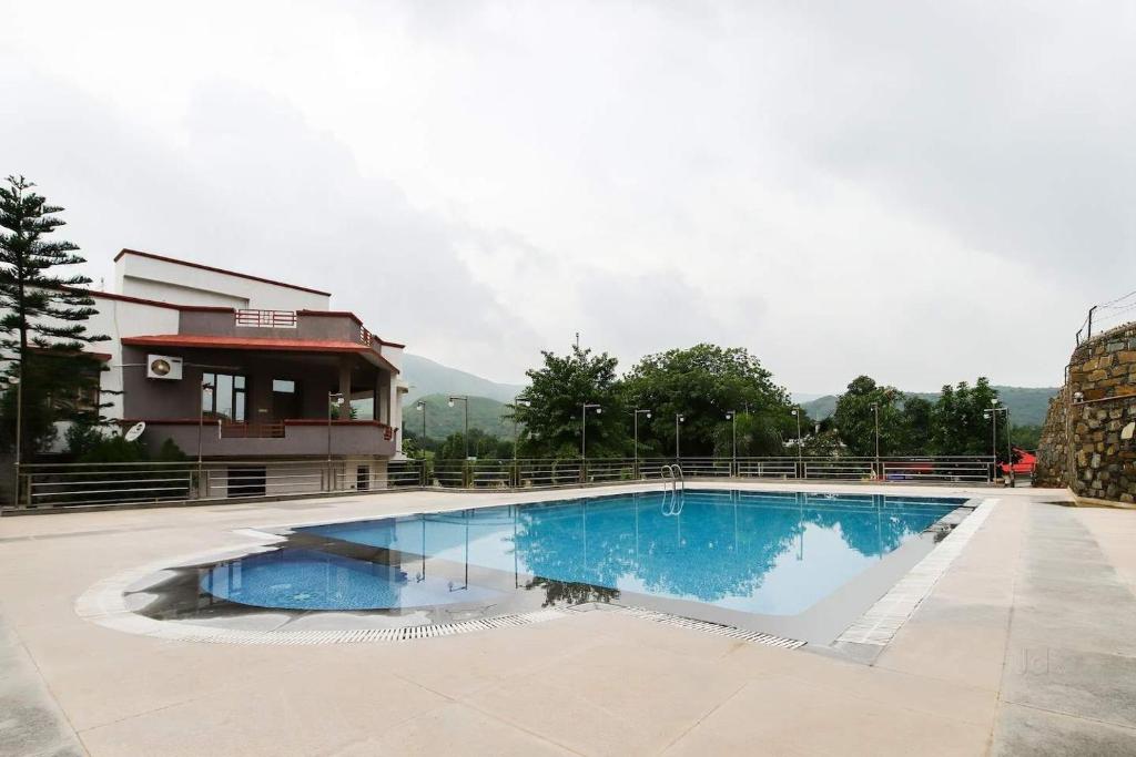 a large swimming pool in front of a building at Meera Valley Resort in Udaipur