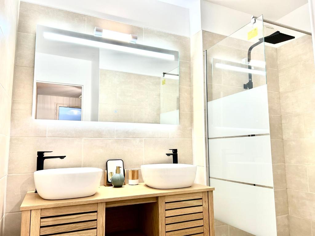 a bathroom with two sinks and a shower at Perle insulaire in Saint-Denis